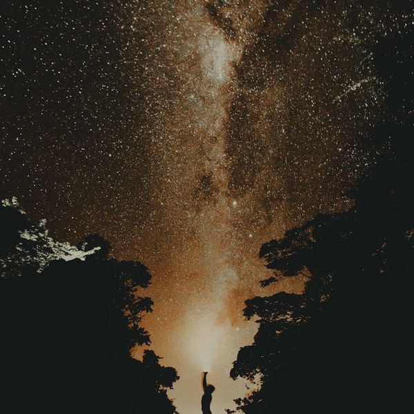 Silhouette of a man in a balanced pose against a dark, cosmic background.